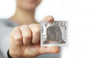 Mujer sosteniendo un preservativo en campañas