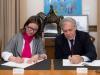 Dos personas firmando un acuerdo